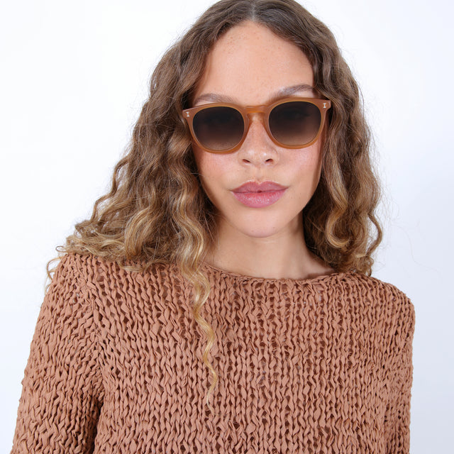 Brunette model with ombre, natural curls wearing Eldridge Sunglasses Matte Honey with Olive Flat Gradient