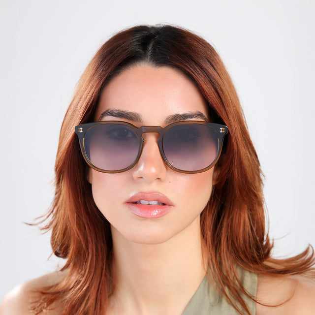 Woman with red hair in an olive blouse wearing Eldridge 56 Sunglasses Moss with Grey Flat Gradient