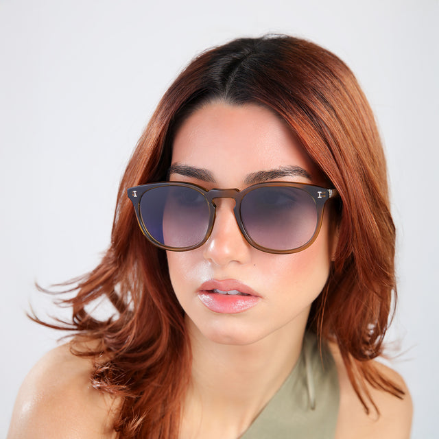 Close up of woman with red hair in an olive blouse wearing Eldridge 56 Sunglasses Moss with Grey Flat Gradient