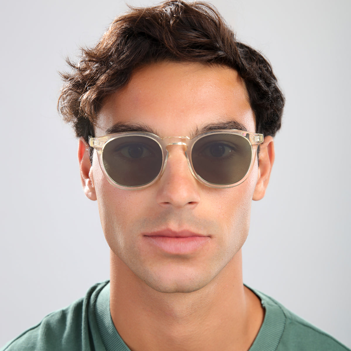 Man wearing Eldridge Sunglasses in Champagne with Olive Flat lenses, front view, Man with brown hair in a green shirt