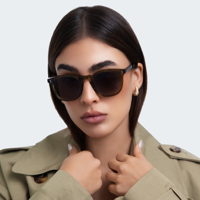 Woman in a trench coat wearing Eldridge Sunglasses Moss with Grey Flat Gradient