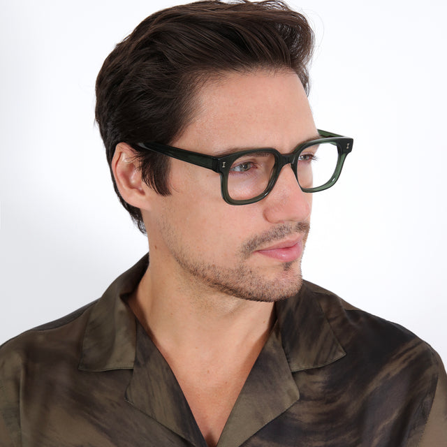 Model with brown hair combed sideways wearing Ellison Optical Pine Optical