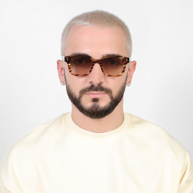 Model with a platinum buzzcut wearing Ellison Sunglasses Sand Dune with Brown Flat Gradient