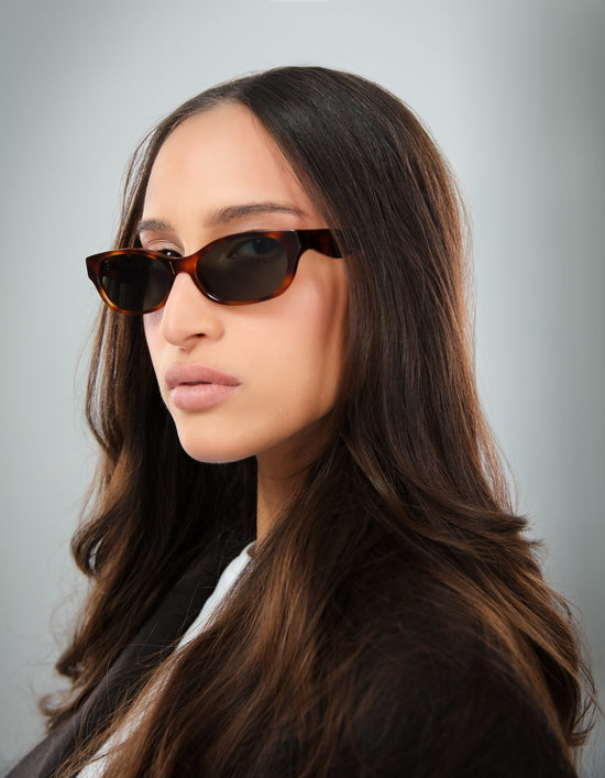 Brunette woman in a black blazer wearing Encinitas in Havana with Grey lenses