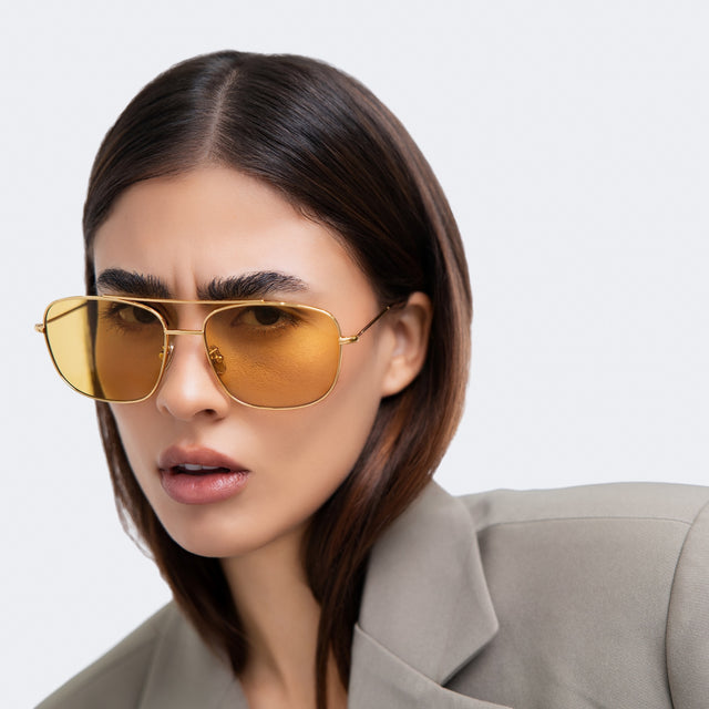 Woman scrunching her face wearing Frankie Sunglasses Gold with Honey Flat See Through