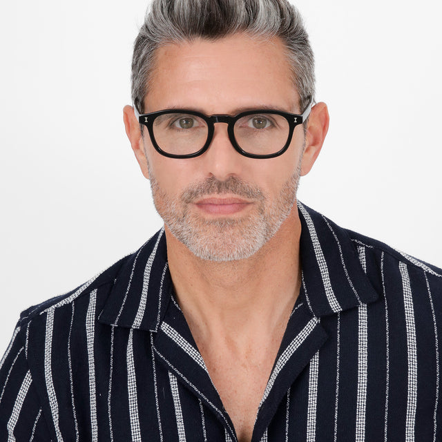 Model with salt and pepper hair and beard wearing Griffith Optical Black Optical