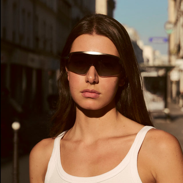 Woman walking in Paris in a white tank top wearing Hopper Sunglasses Silver w/ Grey Gradient