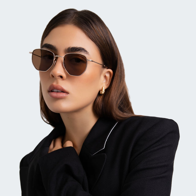 Woman in a black blazer wearing Hunter Sunglasses Gold with Brown