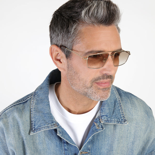 Model with salt and pepper beard looking left wearing Jane Sunglasses Gold with Taupe Gradient