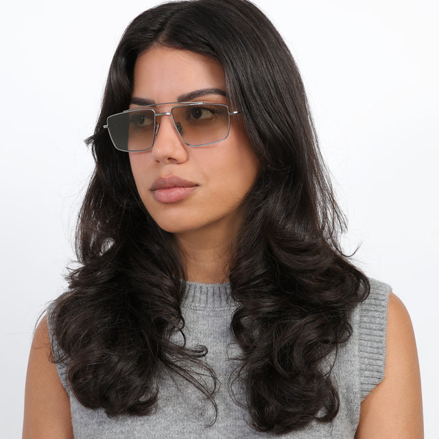 Brunette model with loose curls looking right wearing Jane Sunglasses Gunmetal with Taupe Gradient