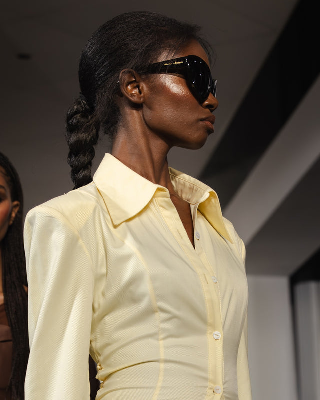 Woman wearing a light-colored shirt and Kim Shui x illesteva sunglasses in black on a runway
