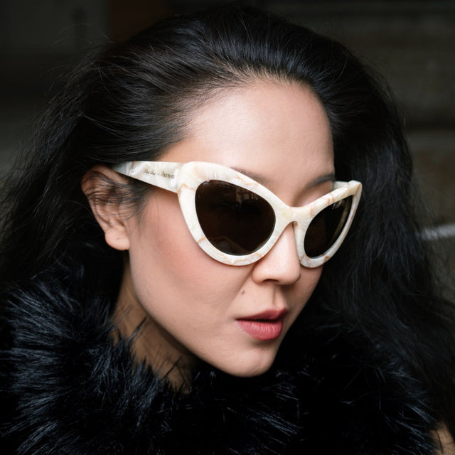 Close up of Kim Shui in a faux fur coat wearing Kim Shui x illesteva Savannah Cream Marble with Grey