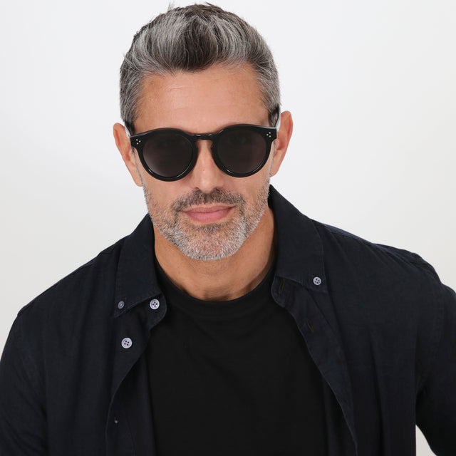 Model with salt and pepper hair and beard wearing Leonard II E Sunglasses Black Grey