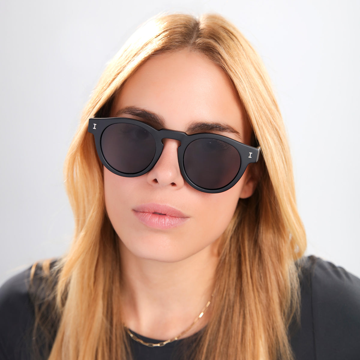 Woman wearing Leonard Polarized Sunglasses in Matte Black with Grey Polarized lenses, front view, Blond woman in a black tee