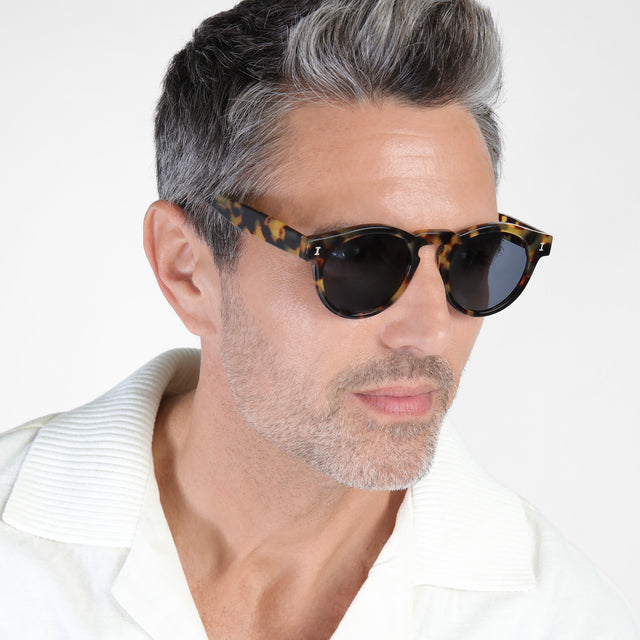 Model with salt and pepper hair and beard wearing Leonard Sunglasses Tortoise with Grey