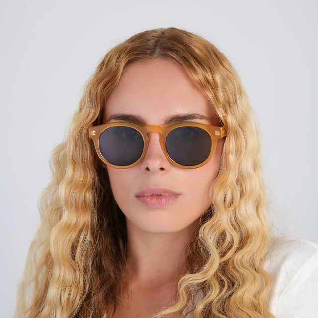 Another angle of woman in a linen blouse wearing Leonard (15 Year Anniversary) Sunglasses Honey Gold with Olive