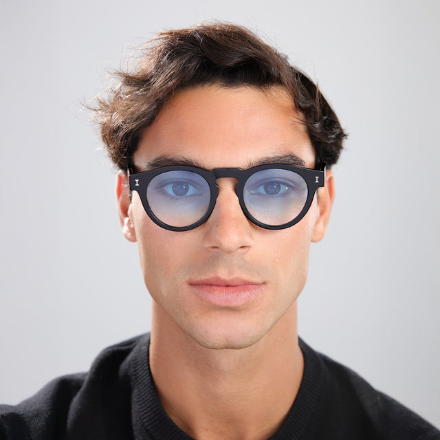 Man in a black tee wearing Leonard Sunglasses Black with Blue Gradient See Through