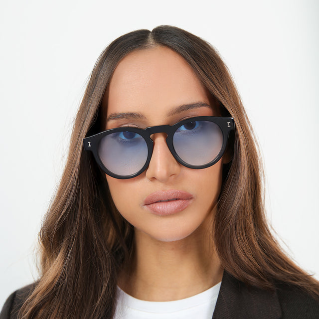 Another angle of woman with brown hair in a white tee wearing Leonard Sunglasses Black with Blue Gradient See Through