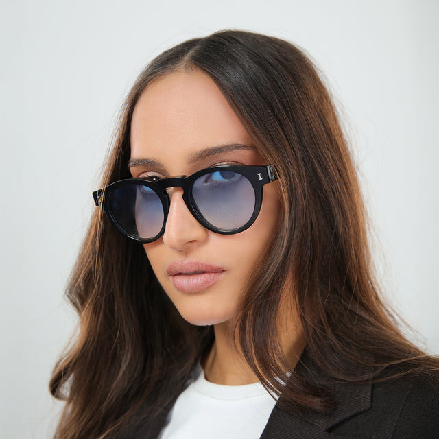 Woman with brown hair in a white tee wearing Leonard Sunglasses Black with Blue Gradient See Through
