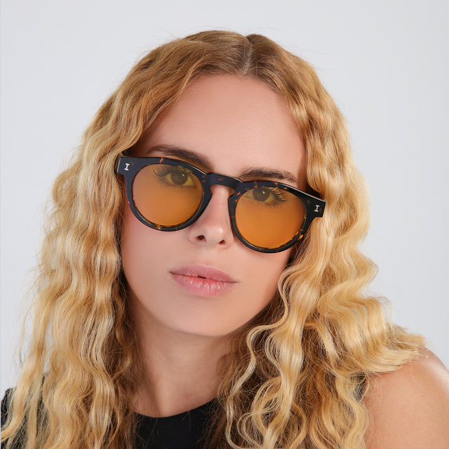 Blond woman with wavy hair wearing Leonard Sunglasses Flame with Honey See Through