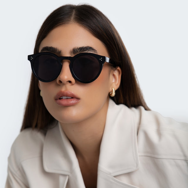 Woman in a white blouse wearing Leonard II E Sunglasses Black with Grey