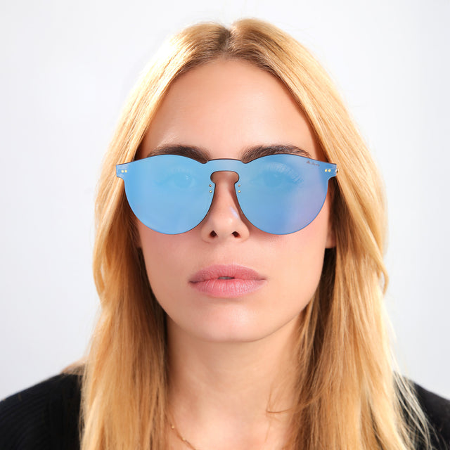 Blond woman in a black tee wearing Leonard Mask Sunglasses Cobalt with Cobalt