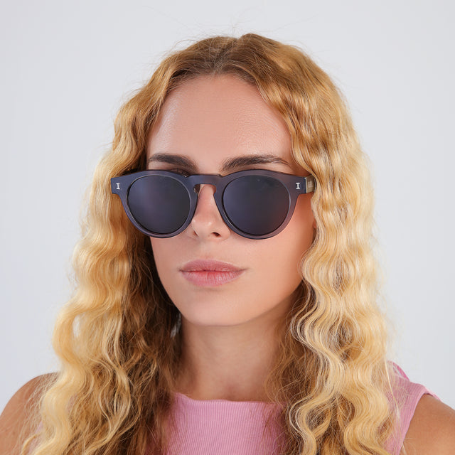 Another angle of blonde woman in a bubblegum pink blouse wearing Leonard Sunglasses Mercury with Grey