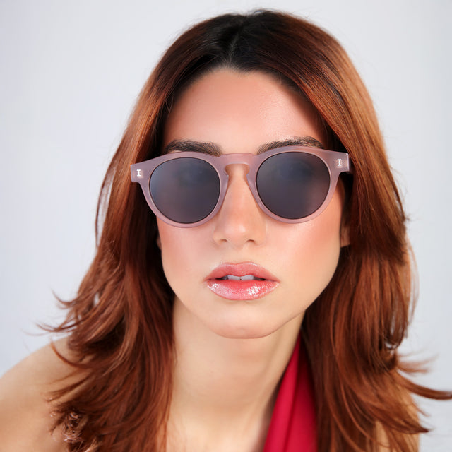 Woman with red hair in a red blouse wearing Leonard Sunglasses Thistle with Grey