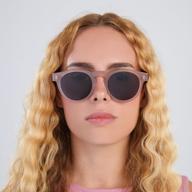 Another angle of blond woman with wavy hair in a pink blouse wearing Leonard Sunglasses Thistle with Grey