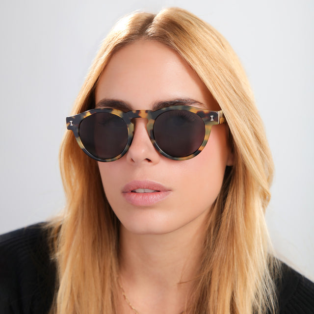 Blond woman in a black tee wearing Leonard Sunglasses Tortoise with Grey