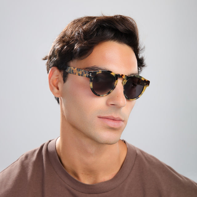 Man in a brown tee wearing Leonard Sunglasses Tortoise with Grey
