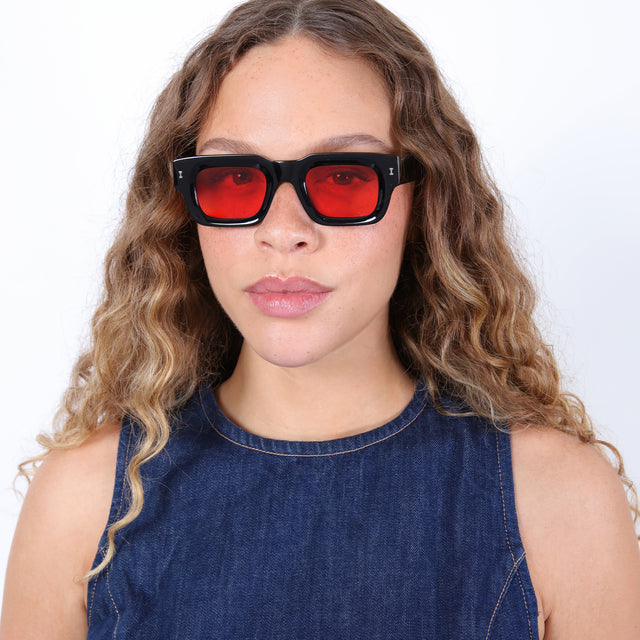 Brunette model with ombré curls wearing Lewis Sunglasses Black with Red Flat See Through