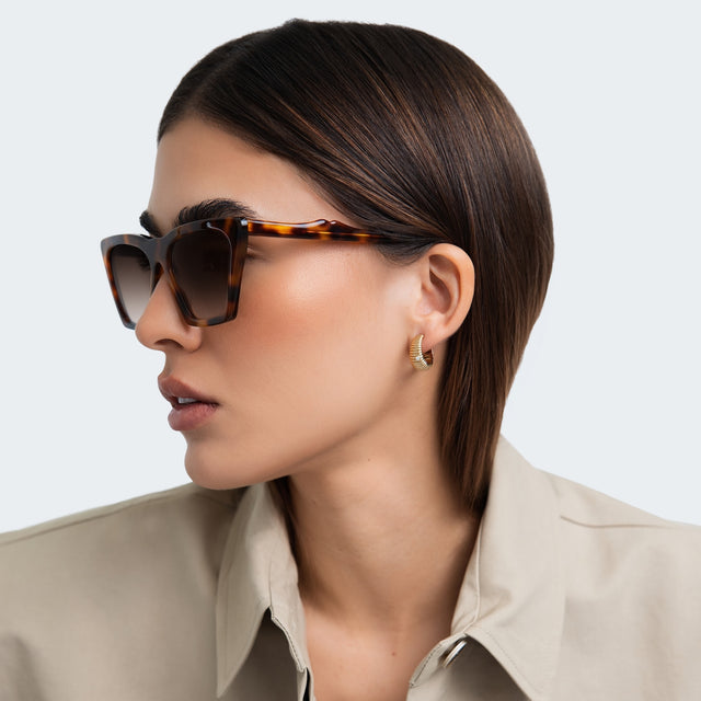 Side profile of woman in a trench coat wearing Lisbon Sunglasses Havana with Taupe Gradient