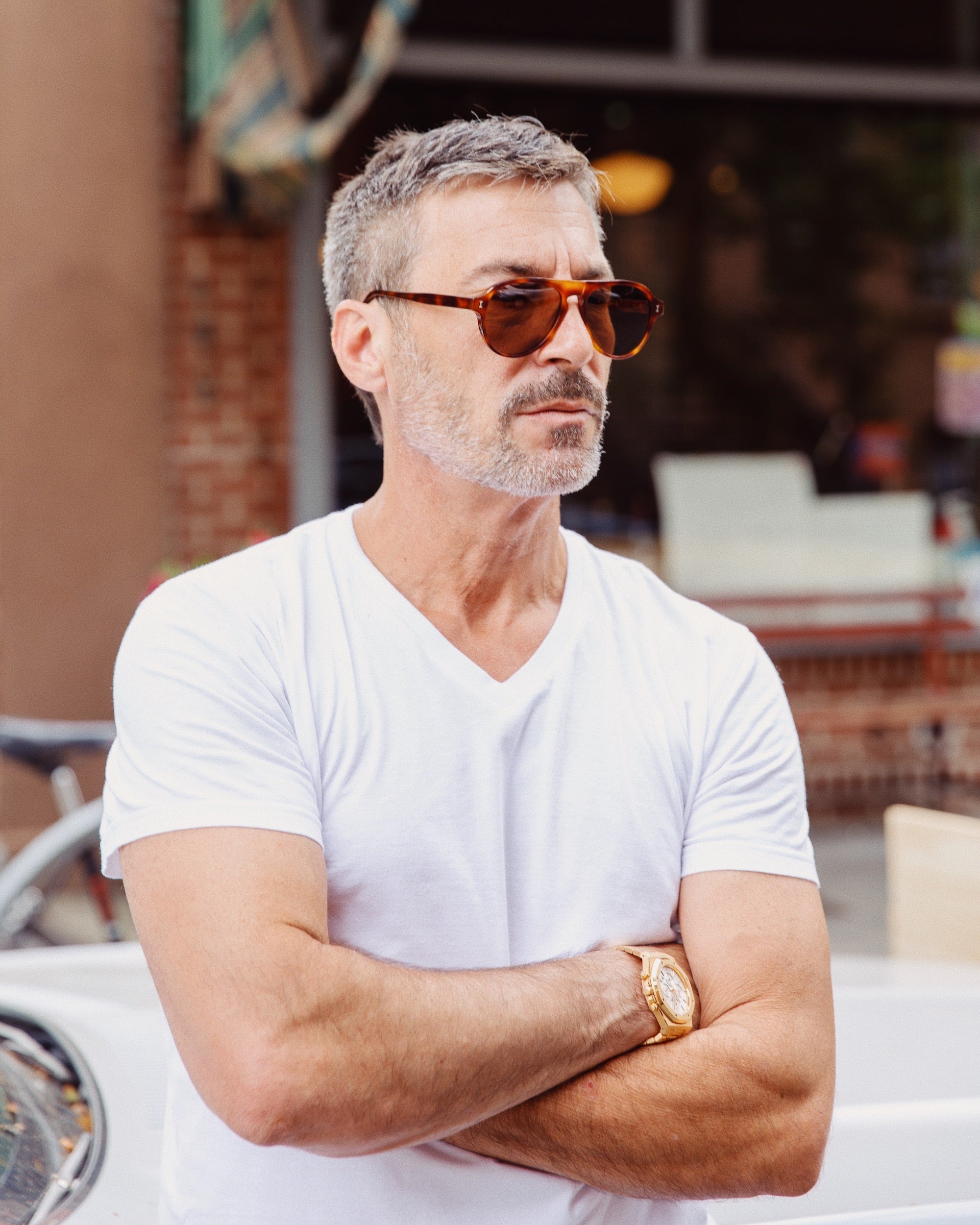 Lucali wearing the collaboration frames in Havana while leaning against his car