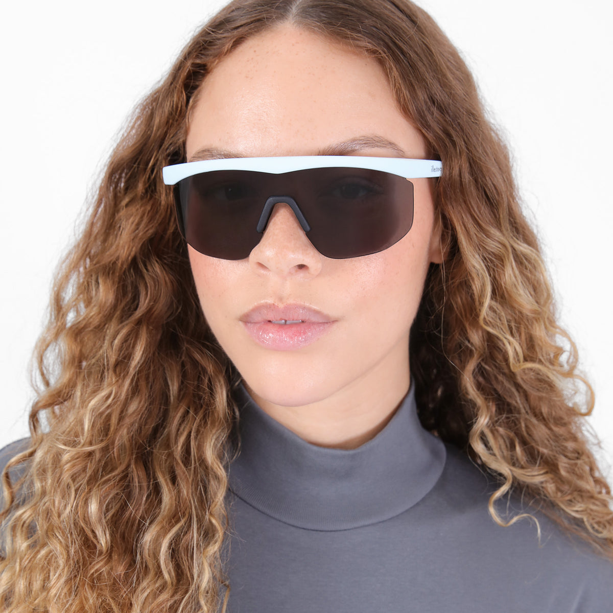 Woman wearing Managua Sunglasses in Matte Baby Blue with Grey lenses, Brunette model with ombré, natural curls