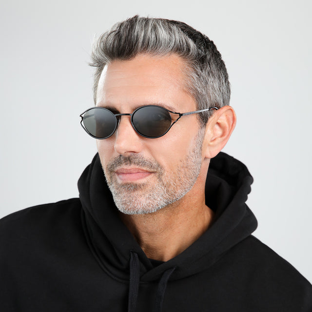 Model with salt and pepper hair and beard looking right wearing Maria Sunglasses Black with Grey
