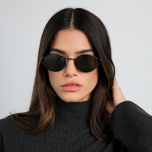 Brunette model in a dark gray turtleneck wearing Maria Sunglasses Black with Grey
