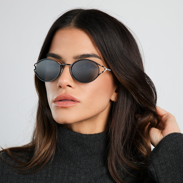 Another angle of brunette model in a dark gray turtleneck wearing Maria Sunglasses Black with Grey