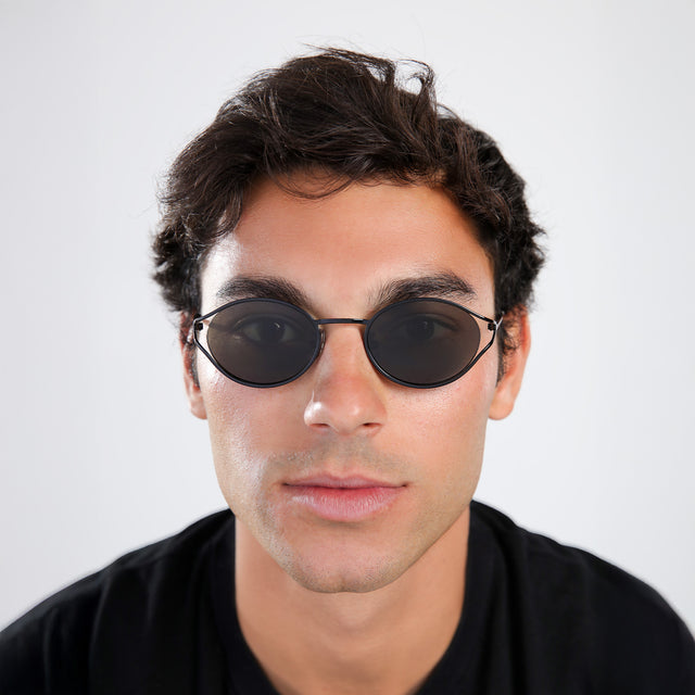 Another angle of man with brown hair in a black shirt wearing Maria Sunglasses Black with Grey