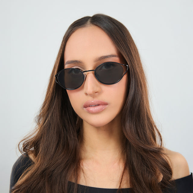 Another angle of woman in an off-the-shoulder blouse wearing Maria Sunglasses Black with Grey