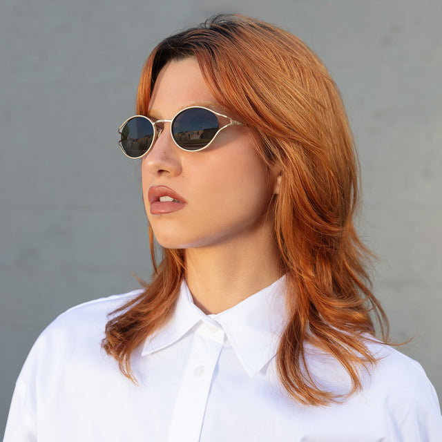 Another angle of red-haired model wearing Maria Sunglasses Gold with Grey