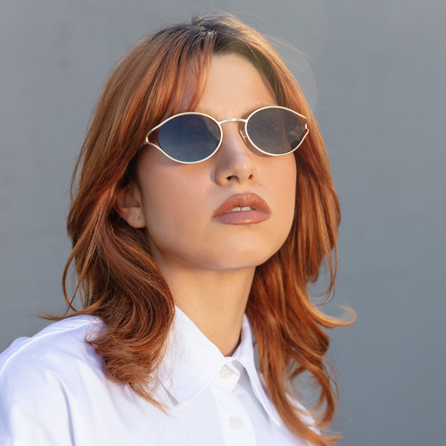 Red-haired model wearing Maria Sunglasses Gold with Grey