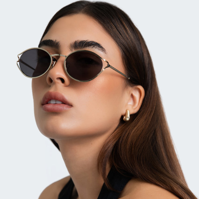 Close up of woman in a black halter blouse wearing Maria Sunglasses Gold with Grey