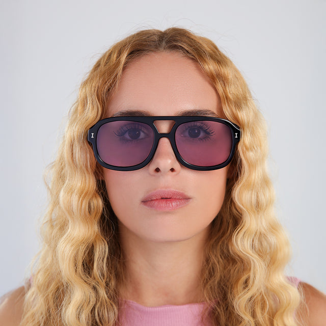 Woman with blonde, wavy hair wearing Memphis Sunglasses Black with Plum See Through