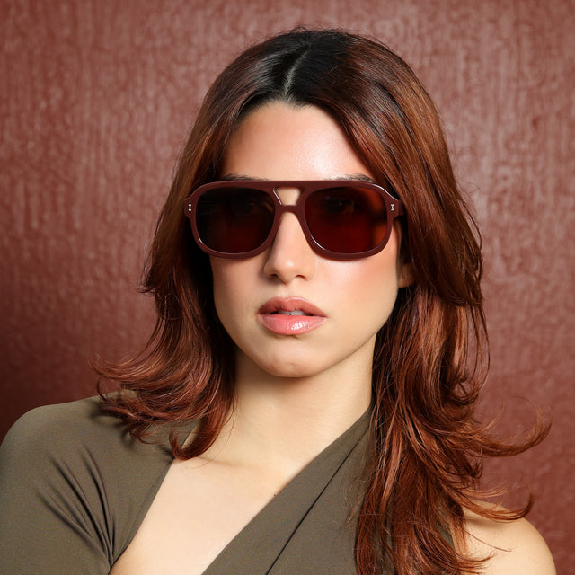 Woman with red hair in an olive blouse wearing Memphis Sunglasses Bordeaux with Brown
