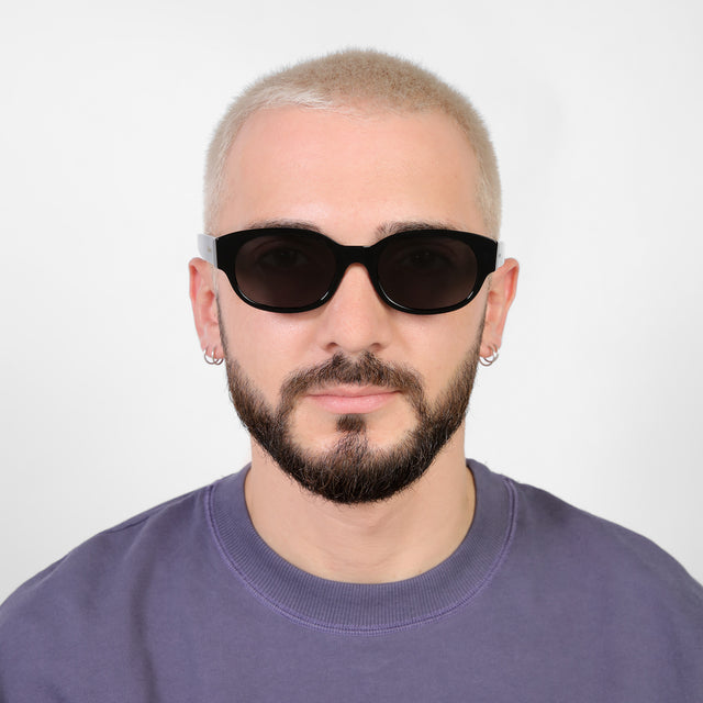 Model with a platinum buzzcut wearing Montreal E Sunglasses Black with Grey Flat