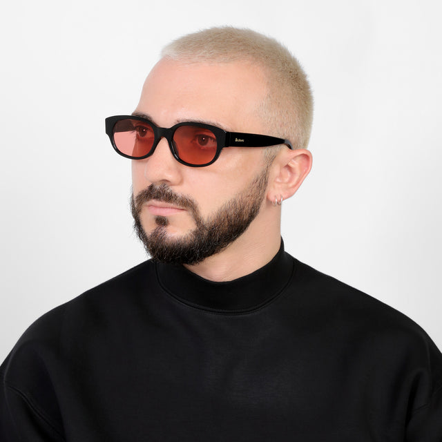 Bearded model looking right wearing Montreal E Sunglasses Black with Guava See Through