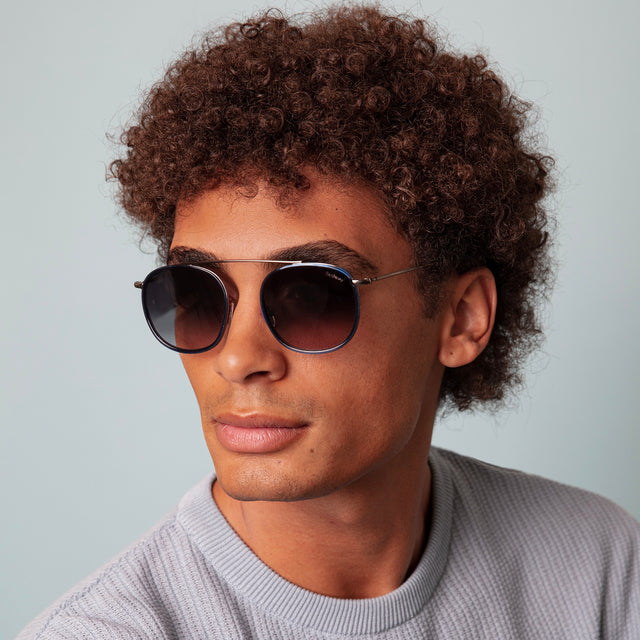 Model with afro-curly hair wearing Mykonos Ace Sunglasses Navy/Gunmetal with Grey Flat Gradient