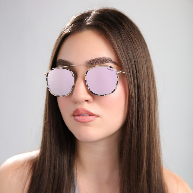 Another angle of brunette woman wearing Mykonos Ace Sunglasses White Tortoise/Gold with Bright Rose Flat Mirror