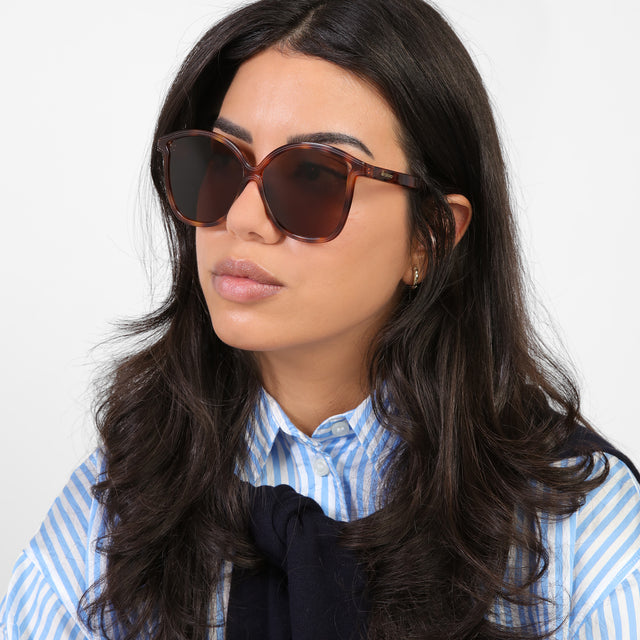 Brunette model in a blue and white striped blouse looking right wearing Nancy 57 Sunglasses Havana with Brown